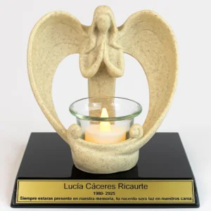 Figura de ángel con vela encendida sobre base negra con placa dorada en memoria de Lucía Cáceres Ricaurte. Homenaje simbólico y luminoso.