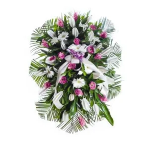 Ramo de pie grande con flores exóticas rosadas, blancas y rojas (ginger, gerberas, lirios), hojas de palma y otras hojas verdes, con un lazo morado y cintas blancas, sobre un fondo blanco.